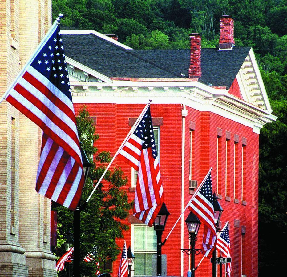 Wall-Mount Flagpole Set includes American flag, rotating pole, and adjustable wall-mount bracket