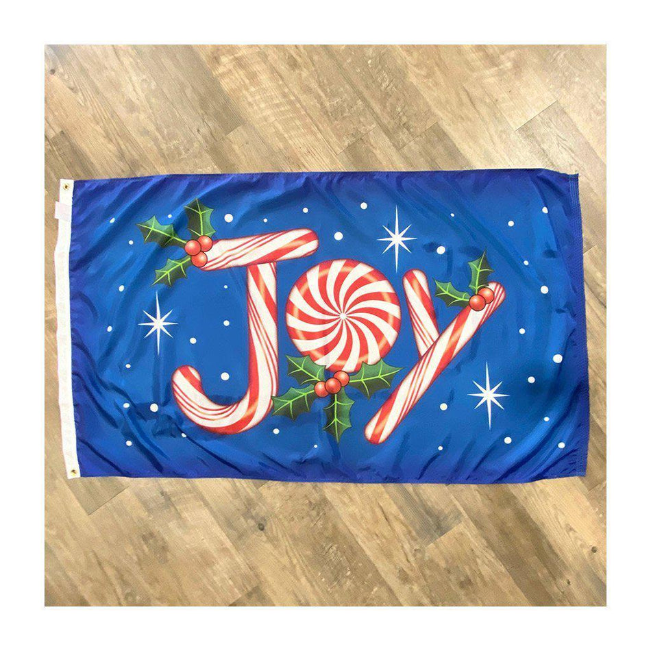 The Christmas Joy 3' x 5' flag features the word "Joy" made out of peppermint candy with holly & berries on a blue background.