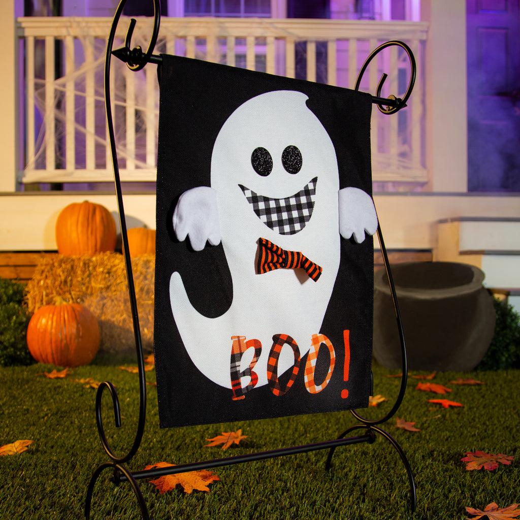 The Girl and Boy Ghost Reversible garden flag features a grinning girl ghost holding a pumpkin basket on the front, and a grinning boy ghost with the word "BOO!" on the back. 