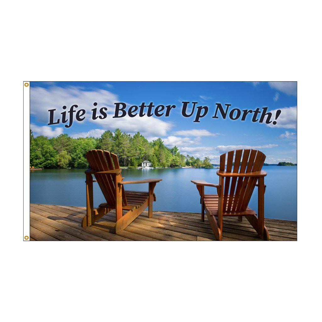 This 3' x 5' flag features adirondack chairs on a pier overlooking the water and the words "Life is Better Up North" across the top of the flag.