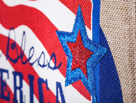 The Patriotic Pick-Up Truck garden flag features a blue truck flying a U.S. flag with a U.S.A. license plate and the words "God Bless America" across the striped tailgate.