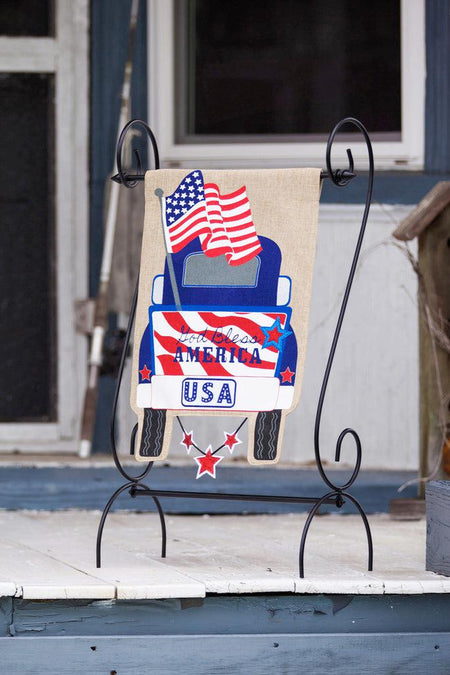 The Patriotic Pick-Up Truck garden flag features a blue truck flying a U.S. flag with a U.S.A. license plate and the words "God Bless America" across the striped tailgate.