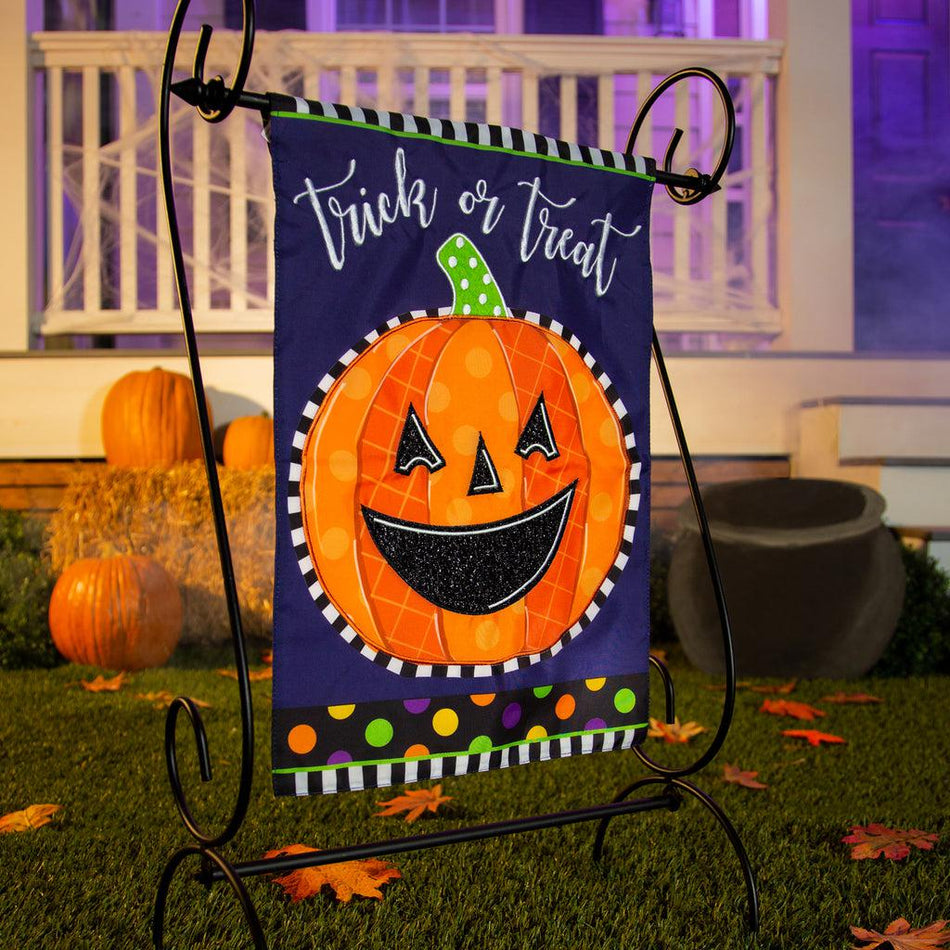 The Patterned Jack-o-Lantern garden flag features a smiling orange patterned jack-o-lantern over a purple background and the words "Trick or Treat". 