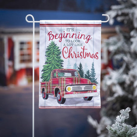 The Plaid Christmas Truck garden flag features a vintage plaid truck, pine trees, and the words "It's Beginning to Look a Lot Like Christmas". 