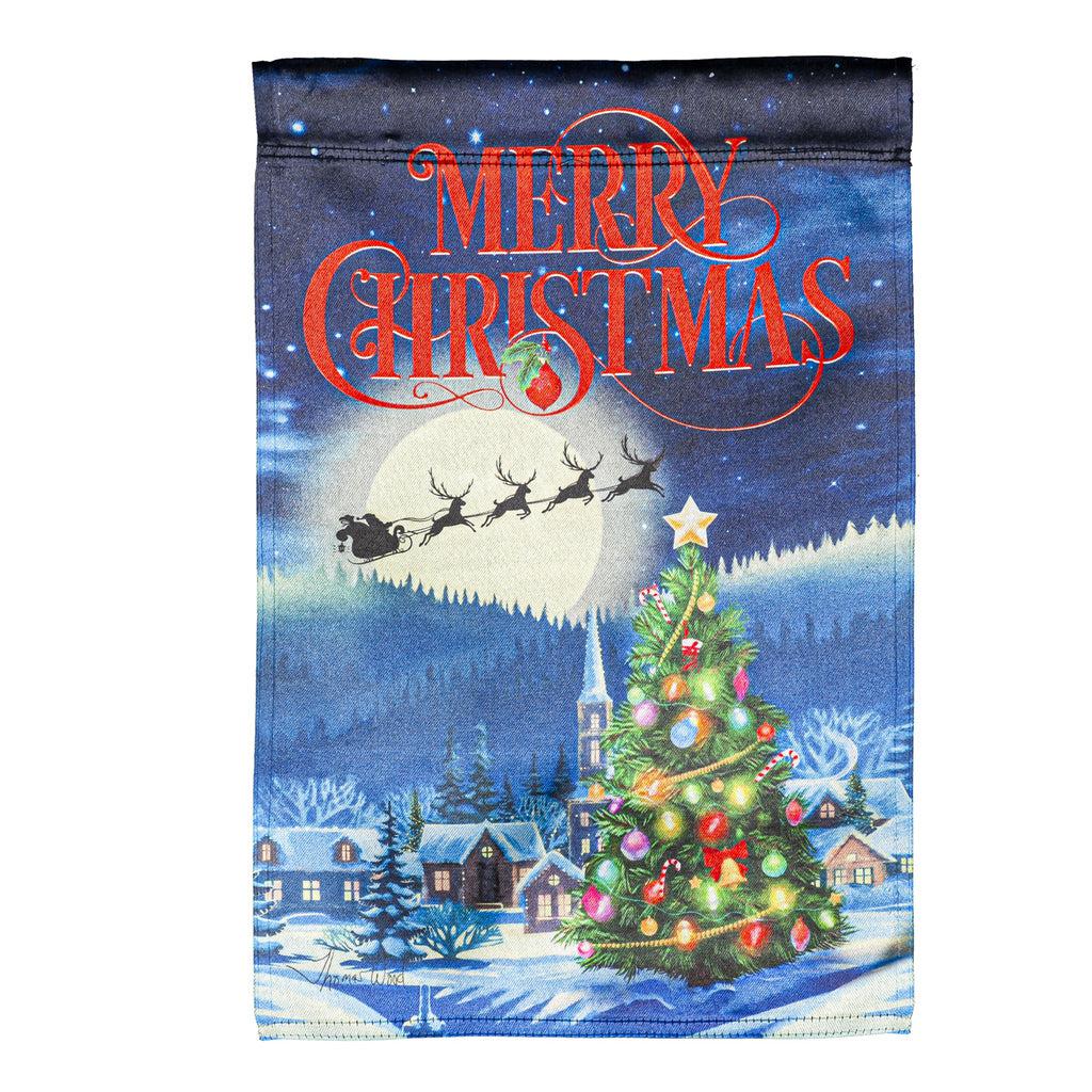 The Santa's Sleigh on Christmas garden flag features Santa and his reindeer flying over a small village with a beautiful Christmas tree, and the words "Merry Christmas" across the top. 